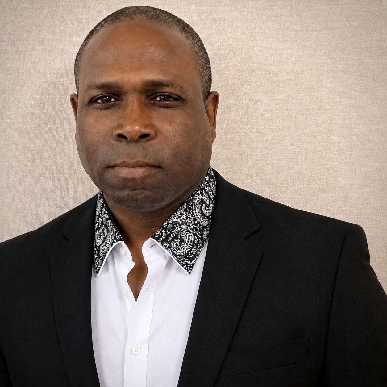 Corey A. Cooper, Founder and CEO of Collar-Ways, in a black suit with a decorative paisley collar